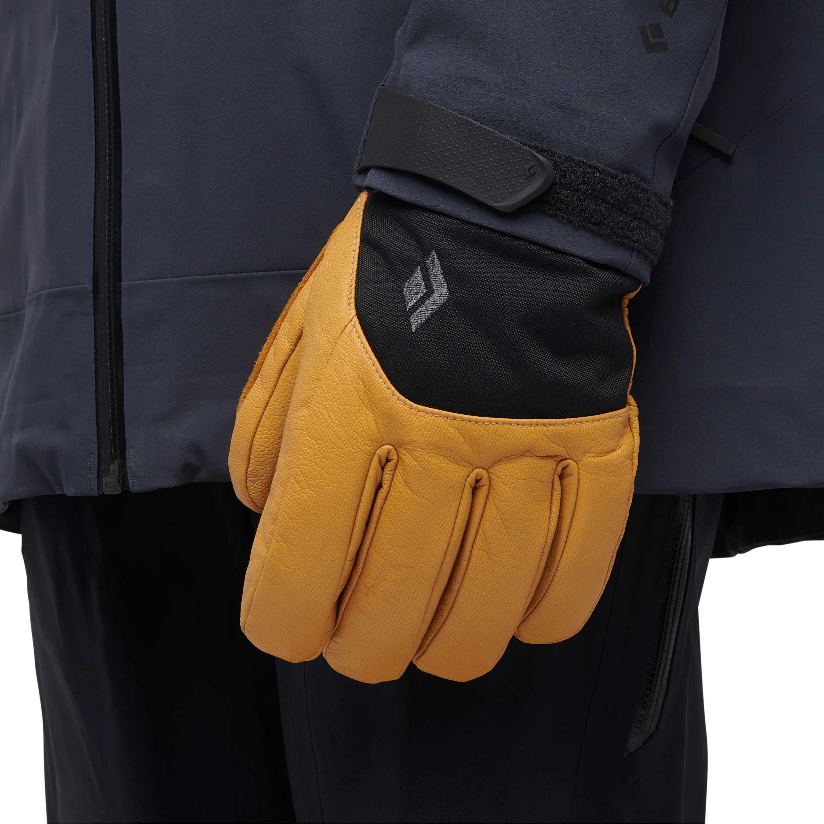 Yellow glove worn by a person in a dark jacket on a white background