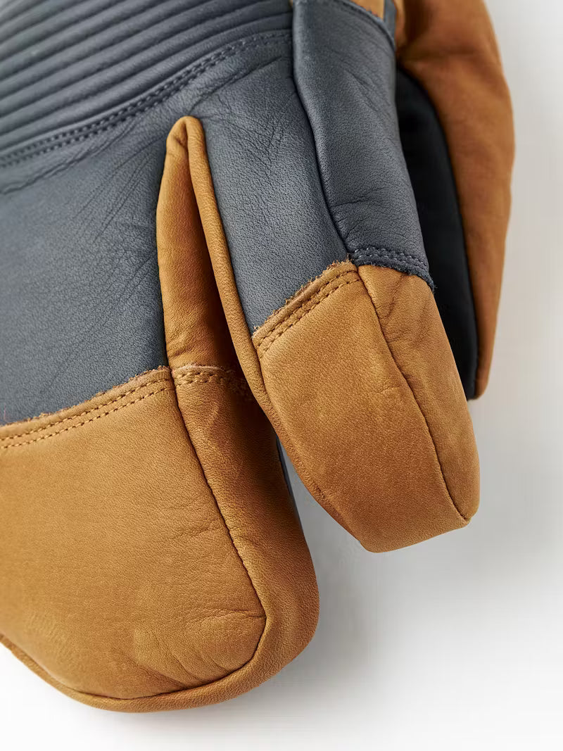 Close-up of brown and gray Hestra gloves on a white background