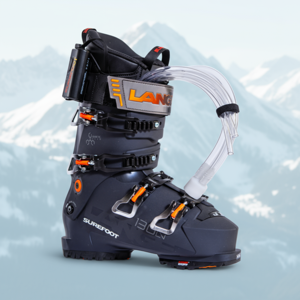 Dark blue ski boot with orange accents on the four buckles. there are tubes coming out of the front that assist in the liner foaming process.
