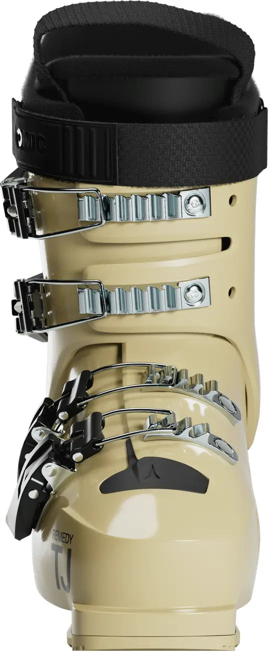 Frontr close up view of a butter colored ski boot with black straps on a white background