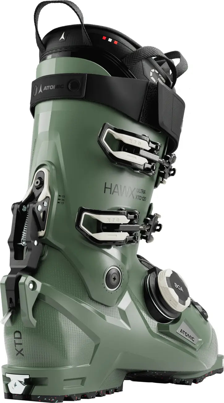 Green ski boot with black accents on a white background with a focus on the hike/walk mode.