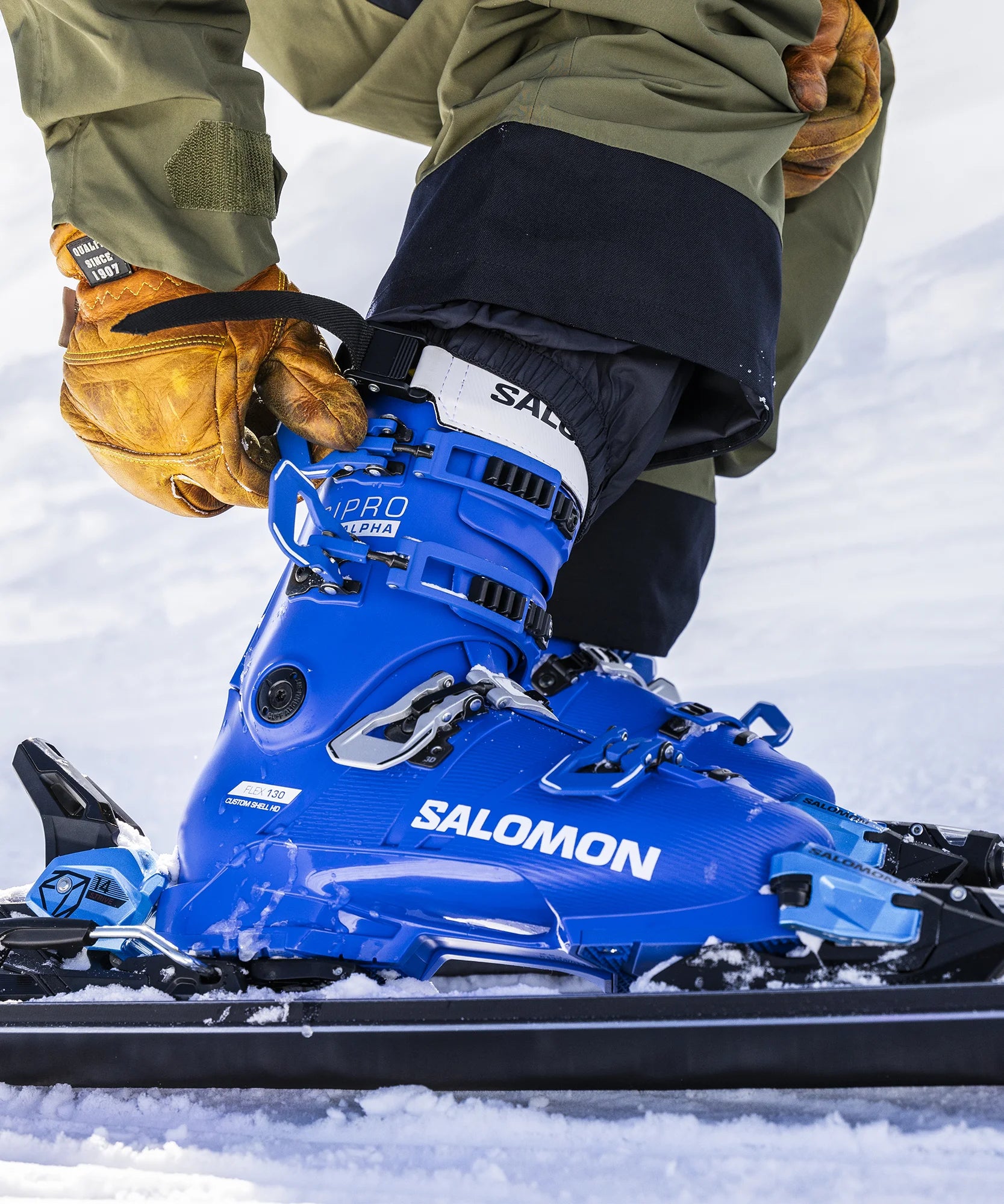 A Salomon S/Pro Alpha ski boot buckled into the binding and on snow.