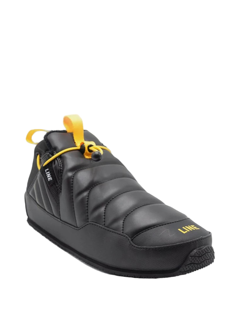 Black slip-on shoe with yellow accents on a white background