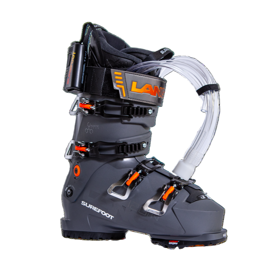 Dark grey ski boot with 4 black buckles with orange accents. Tubes coming out of the tongue are for foaming the ski boot liner.