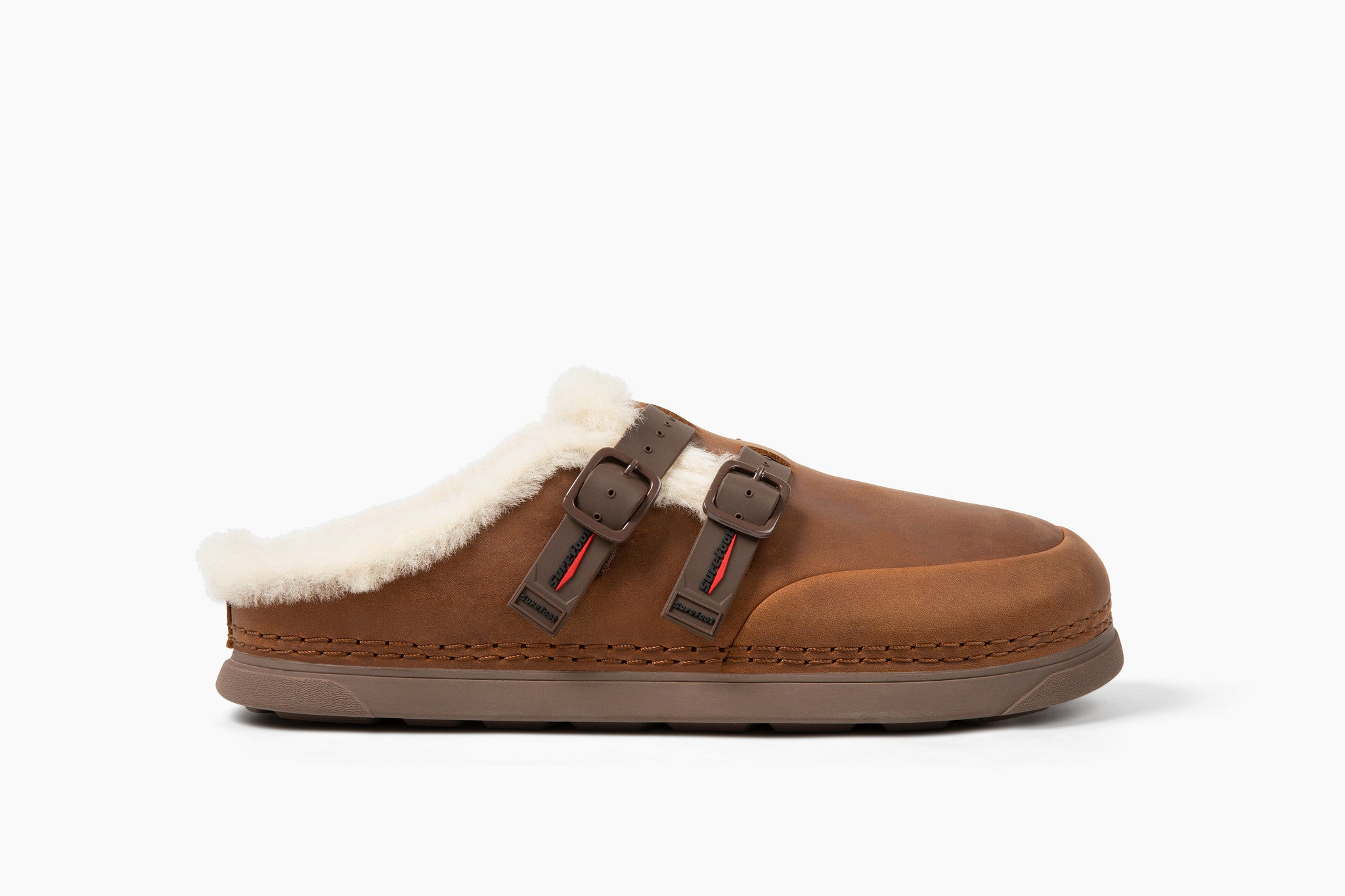 A single brown slip-on clog-style slipper with white shearling lining and two brown buckle straps, shown in profile against a clean white background.