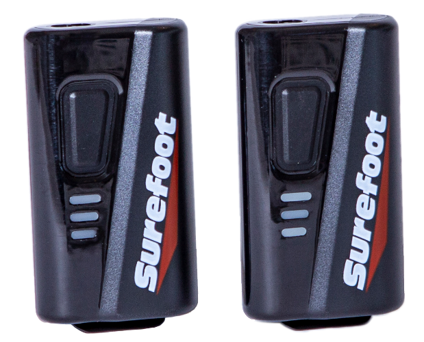 Two small black battery packs with button and Surefoot logo.