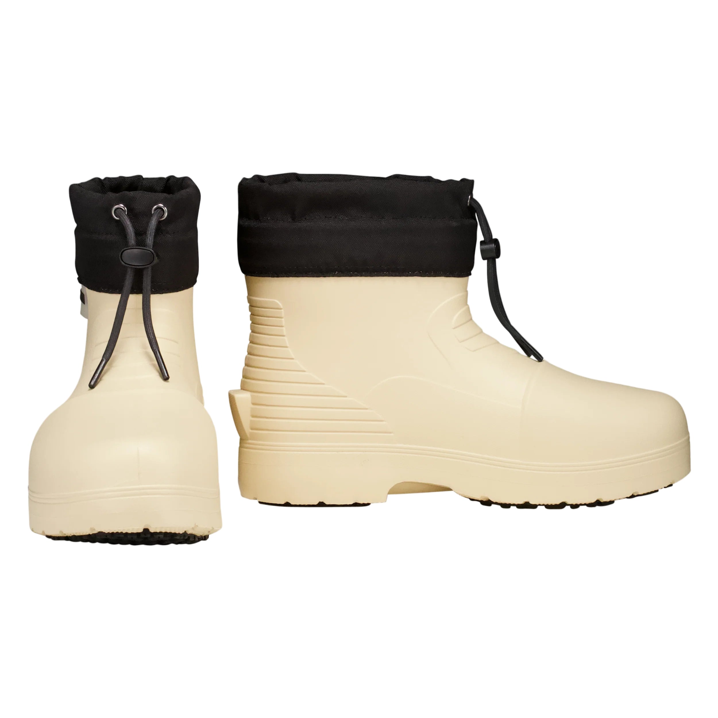 Pair of beige rubber boots with black cuffed tops on a light gray background